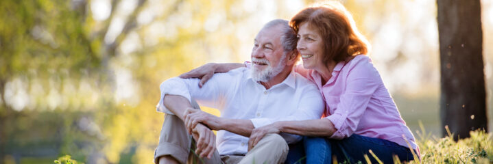 Beautiful senior couple outside in spring nature, hugging.